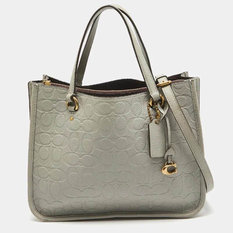 Coach Dempsey bags with a contrast - colored interior for visual interestGrey Signature Embossed Leather Tyler Carryall Tote